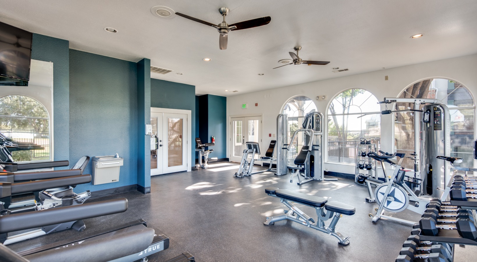 a gym room with exercise equipment and a television at The  Montgomery