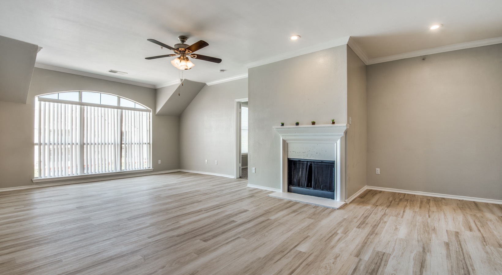 empty living room with hardwood floors and ceiling fan at The  Montgomery