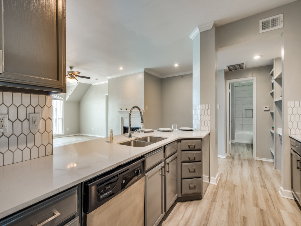 a kitchen with stainless steel appliances and wood floors at The  Montgomery