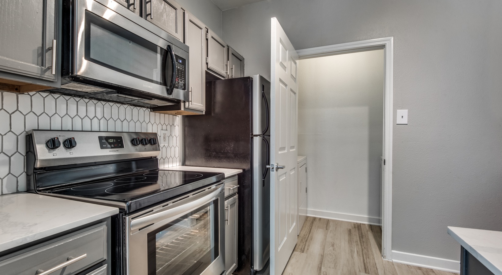 kitchen with stainless steel appliances and white cabinets at The  Montgomery