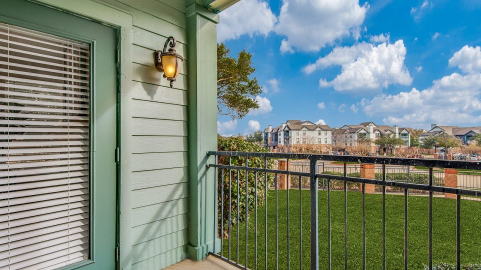 a balcony with a view of the grass and trees at The  Montgomery