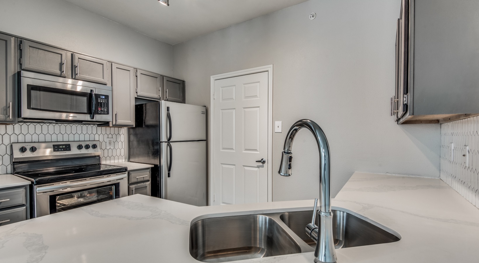 a kitchen with stainless steel appliances and a sink at The  Montgomery