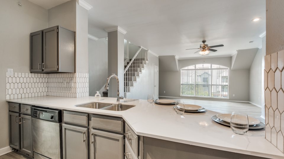 a kitchen with stainless steel appliances and white cabinets at The  Montgomery